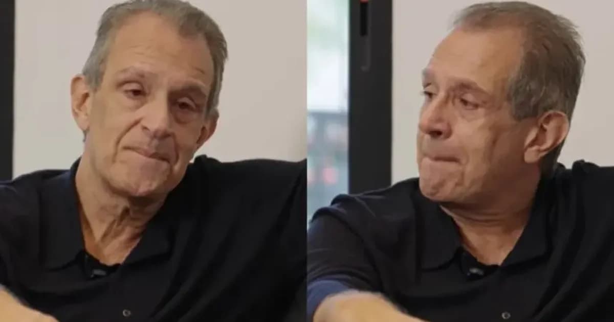 Executivo do Flamengo observa treinador sair do estádio à noite, torcida desfocada e clima tenso, simbolizando mudança de poder.