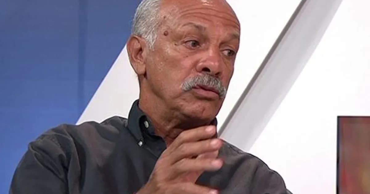 Diretor em coletiva no estádio, comentarista em telão e torcida dividida com faixas vermelhas e pretas; clima de crítica ao Flamengo.