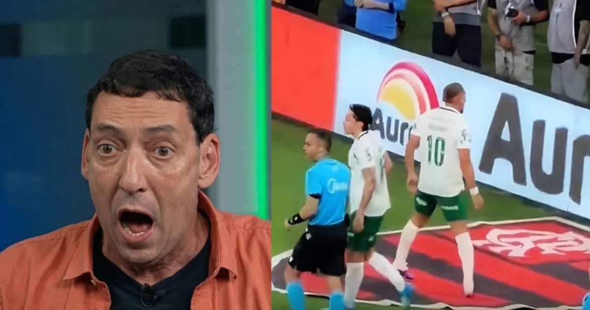 Jogador pisa em escudo vermelho e preto pintado no gramado do Maracanã, com multidão, celulares e polêmica.