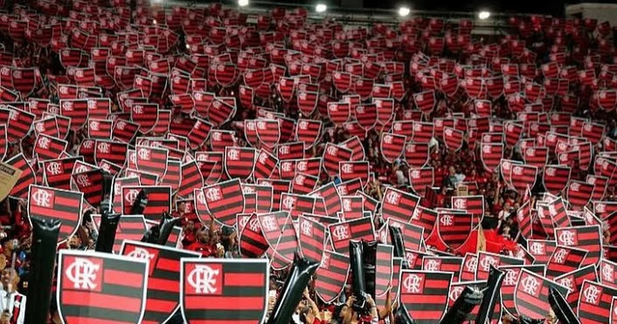 Torcida organizada em estádio com faixas vermelhas e pretas pedindo mudanças; protesto e clima de pressão contra comissão técnica.