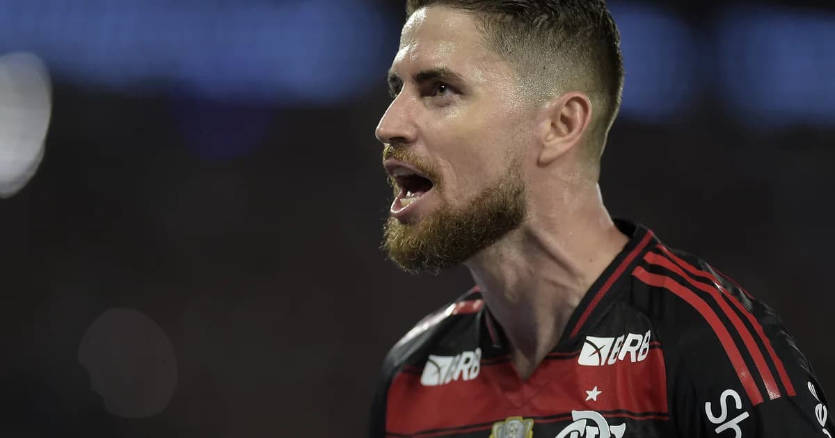 Capitão com braçadeira no gramado do Nilton Santos, torcida vibrando, cores rubro‑negras e comemoração da vitória.