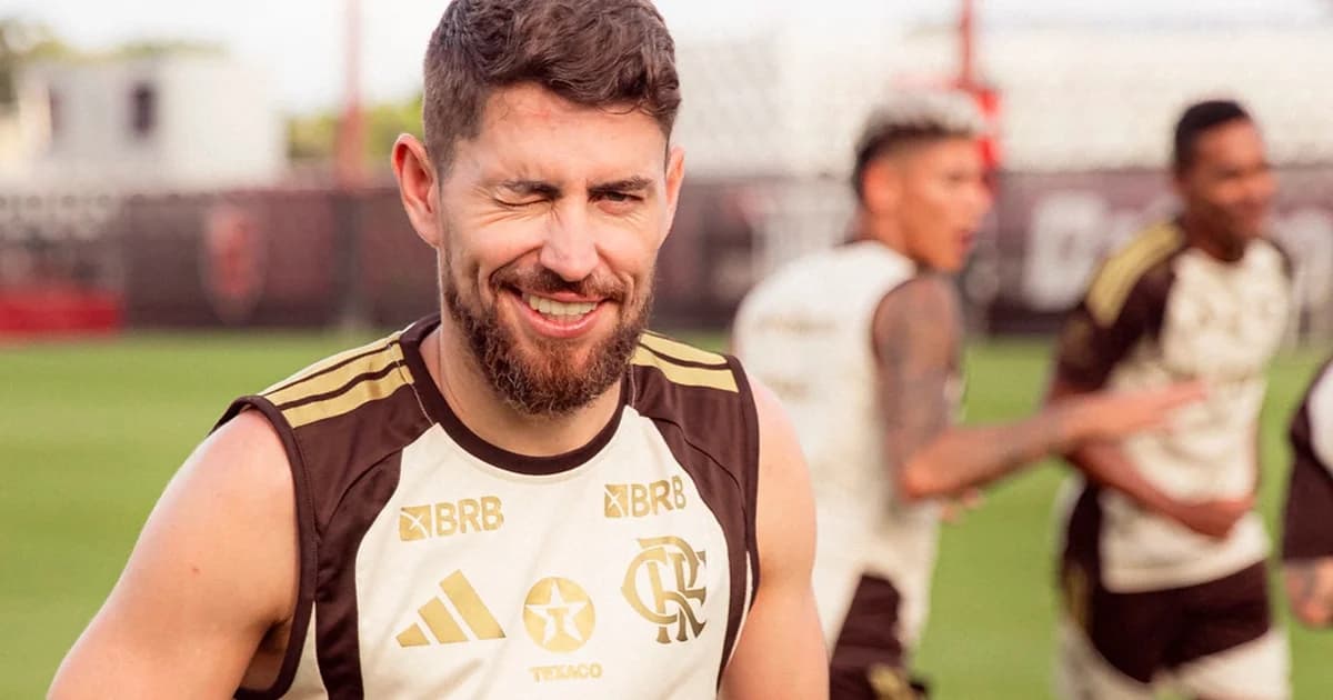 Jorginho jogando futevôlei na praia do Rio após treino, silhueta do jogador na areia com mar e montanhas ao fundo