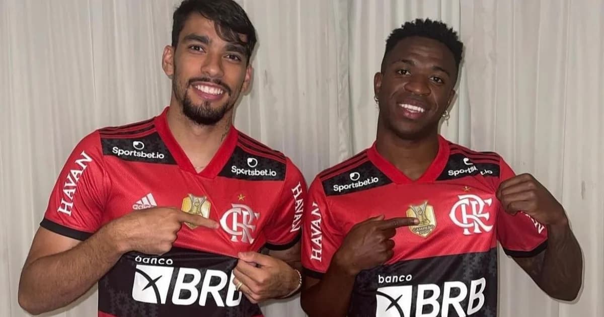 Ilustração editorial: reencontro simbólico de dois jogadores brasileiros em estádio rubro-negro, torcida e clima de esperança (Paquetá, Vinicius Júnior)