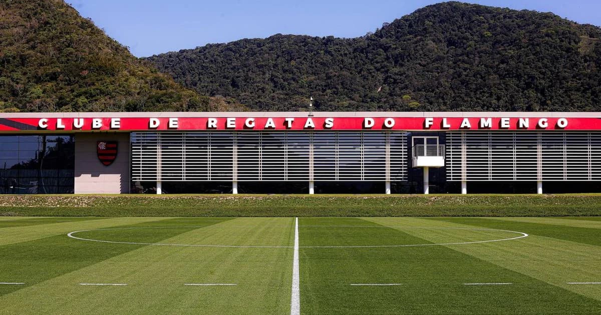 Estádio do Flamengo ao entardecer, contrato de transferência rasgado, calculadora e torcida em vermelho e preto
