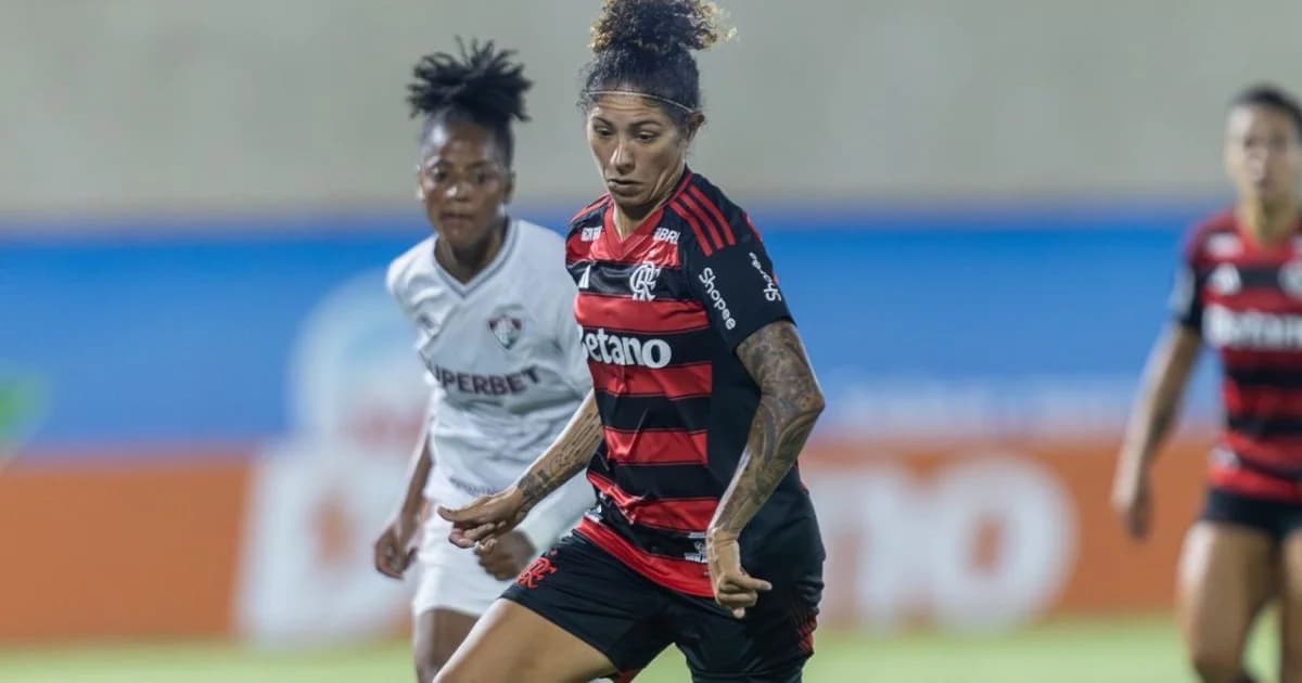 Torcida no estádio vibrando pelo futebol feminino; fãs mostram cupons digitais de R$50, cores vermelha e preta, atmosfera de campanha.