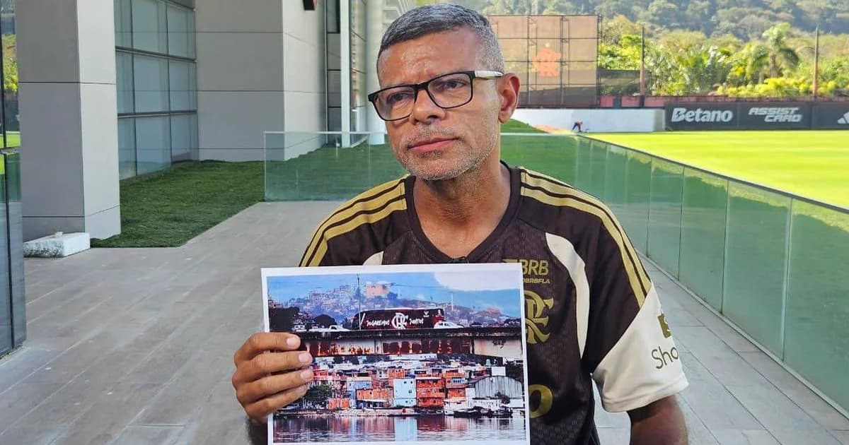 Fotógrafo do Flamengo na beira do campo em jogo da Libertadores, torcida rubro-negra ao fundo e ação de futebol sem rostos visíveis.
