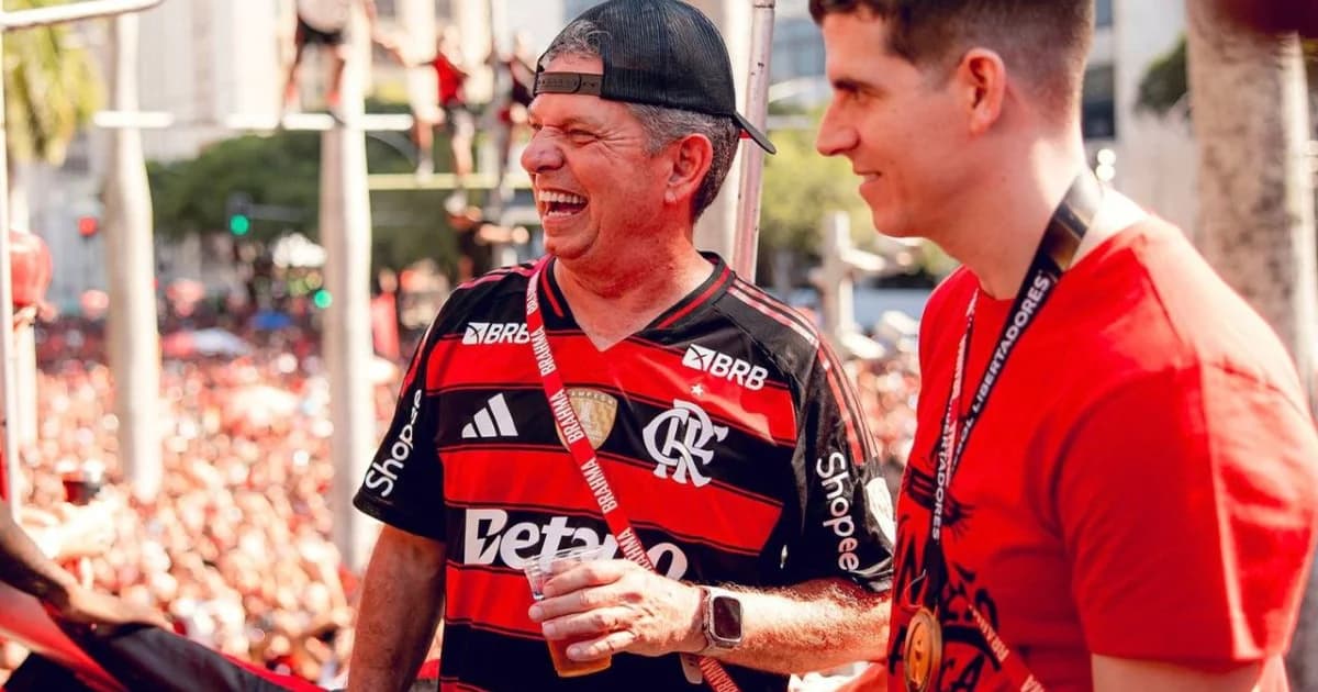 Camisa rubro‑negra com área de patrocínio coberta (patrocinador Betano), mãos retirando adesivo, estádio e documento MP 1.394/2026.