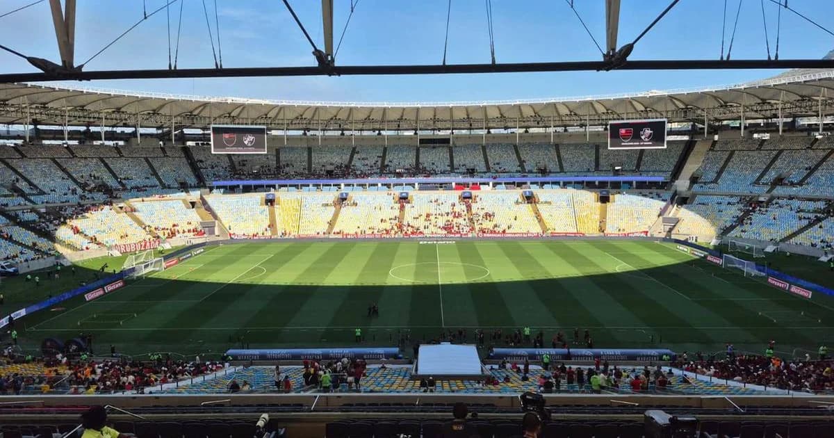 Maracanã vazio ao entardecer, gramado em recuperação, documentos jurídicos em destaque e funcionários trabalhando — defesa do Flamengo
