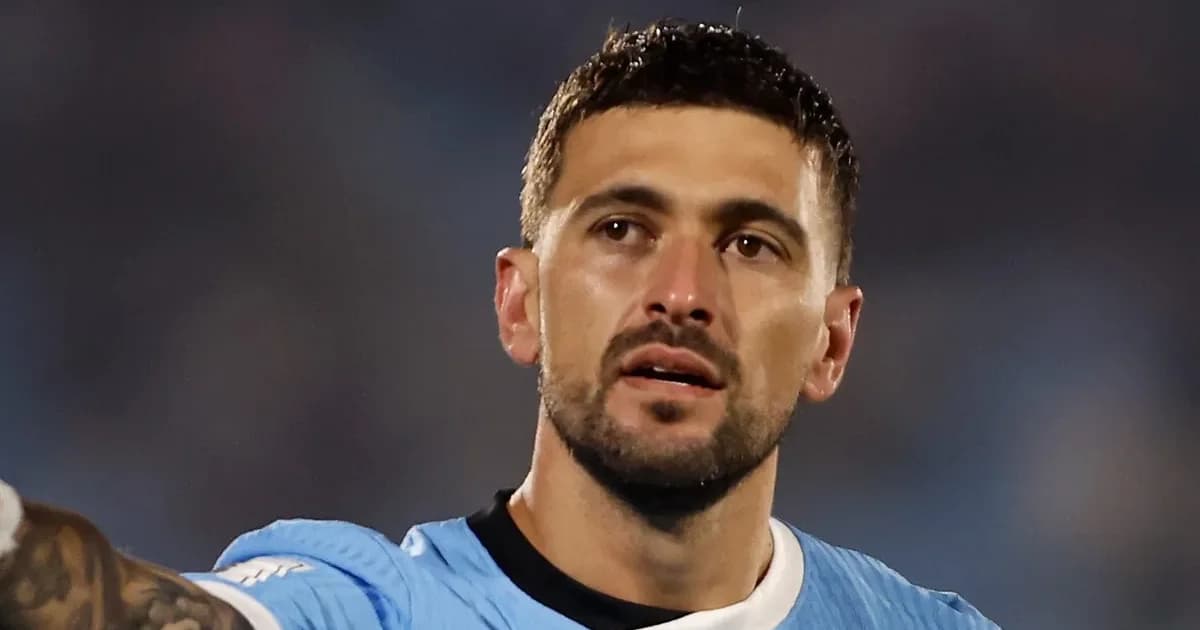 Jogador com panturrilha enfaixada na beira do campo, fisioterapeuta ao lado e quadro com lista da seleção para a Copa em estádio iluminado.