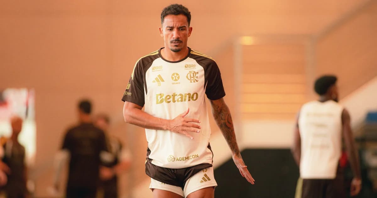 Zagueiro solitário no gramado, expressão de frustração após eliminação na Copa, estádio vazio e iluminação dramática ao fundo