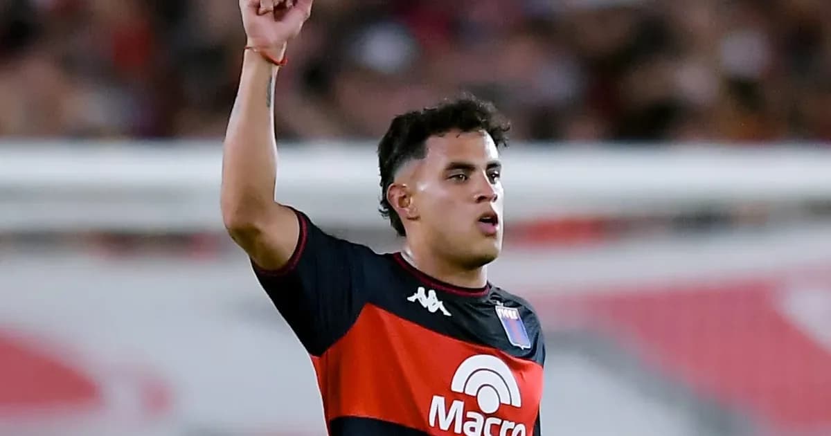 Estádio ao entardecer com silhueta de atacante em ação, bandeiras rubro-negras e contrato flutuante simbolizando interesse do Flamengo