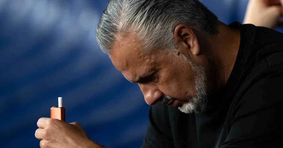 Treinador sem rosto na beira do campo, torcida tensa com faixas vermelho e preto; pressão sobre o Flamengo no Campeonato Brasileiro