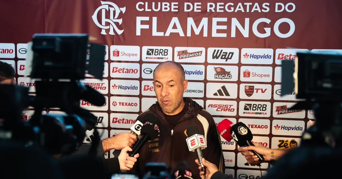 Treinador gesticulando em estádio da Libertadores, torcida do Flamengo em vermelho e preto, placar indicando partida suspensa.