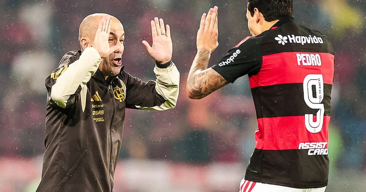 Atacante número 9 do Flamengo em recuperação, correndo com a bola na área; torcida vibrando e técnico observando na lateral.