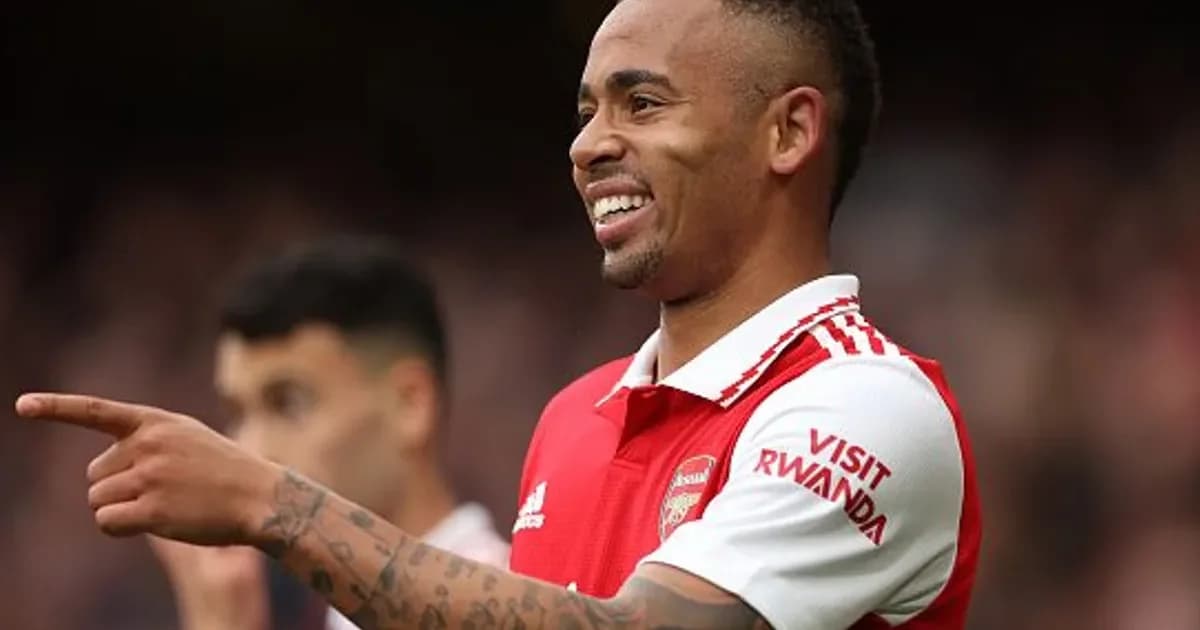 Atacante sem rosto em ação em estádio com bandeiras vermelho-e-preto, documentos de transferência e torcedores (Flamengo, Arsenal)
