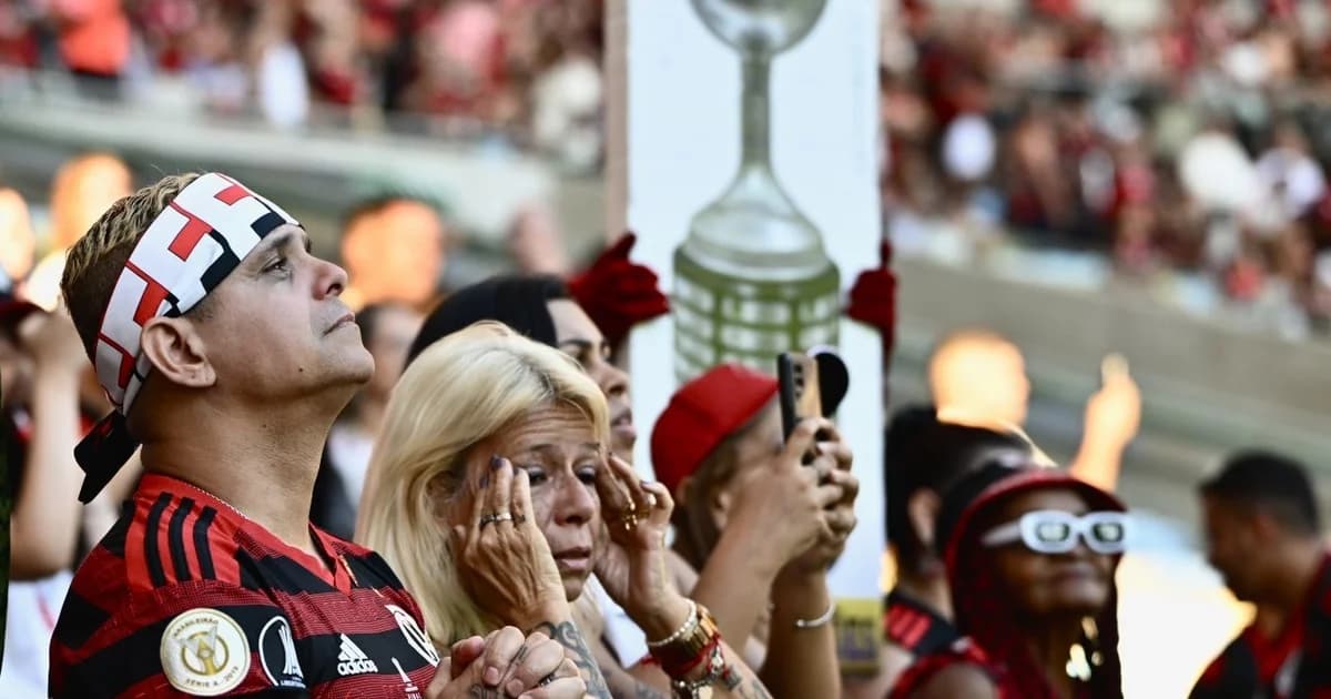 Ilustração editorial: torcida no estádio ao pôr do sol, mãos segurando cartão do sócio-torcedor anual, cores vermelho e preto, Nação Sem Fronteiras.