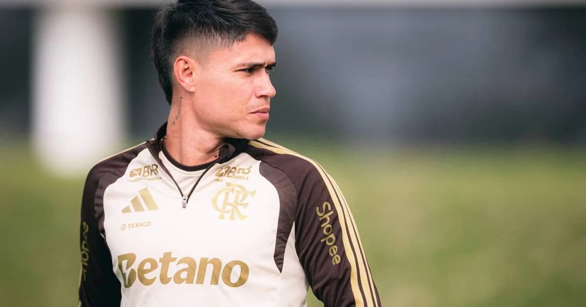 Atacante do Flamengo retornando ao jogo no estádio ao entardecer, torcida rubro-negra vibrando e joelho com proteção