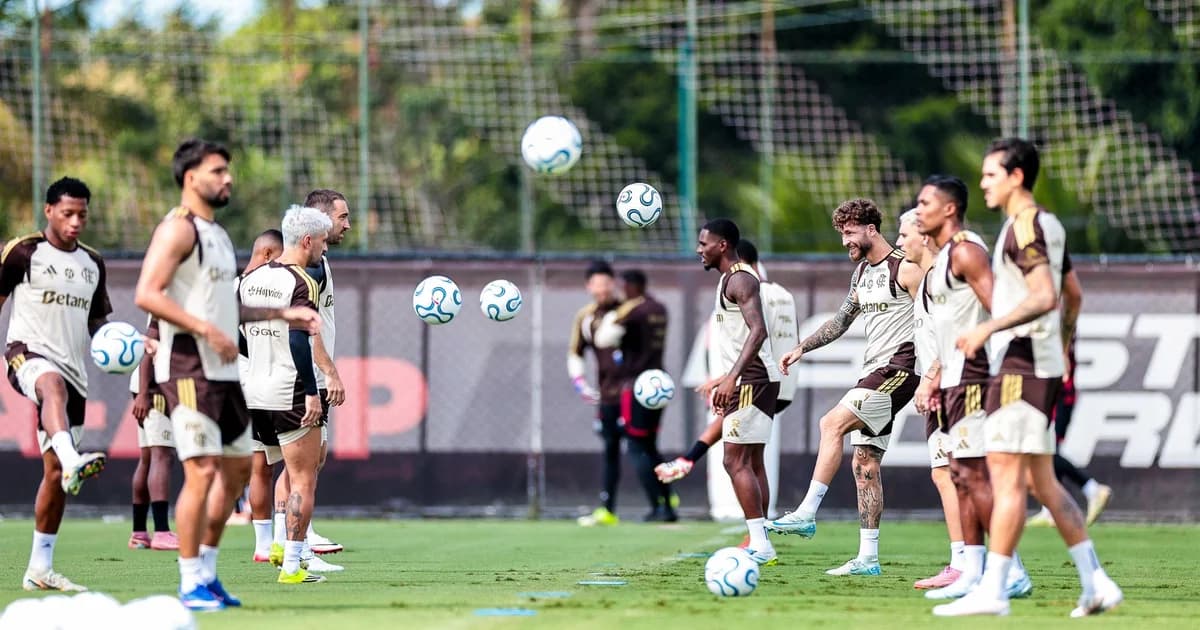 Treino do Flamengo: jogador fora com ombro imobilizado no banco, companheiros aquecendo no gramado, preparação para a Libertadores
