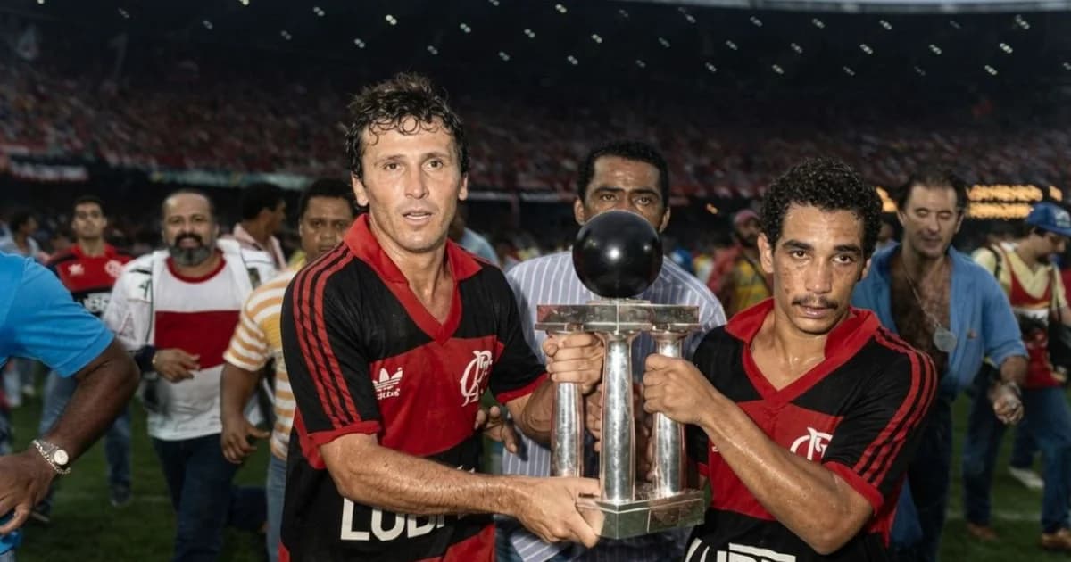 Taça dourada em cofre de banco com tribunal e torcida ao fundo, simbolizando disputa jurídica pela posse do troféu.