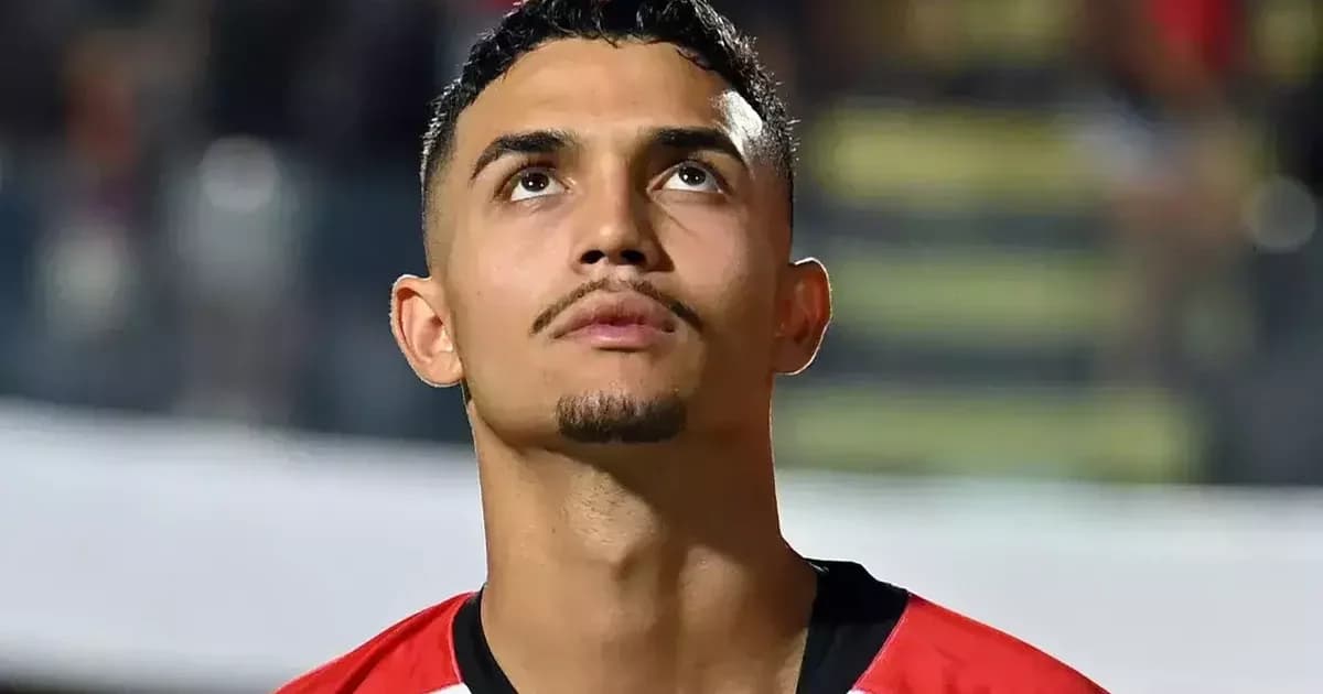 Zagueiro jovem no estádio ao entardecer com plaquinha €30M flutuando; torcida e executivos ao fundo, negociação e mercado de transferências