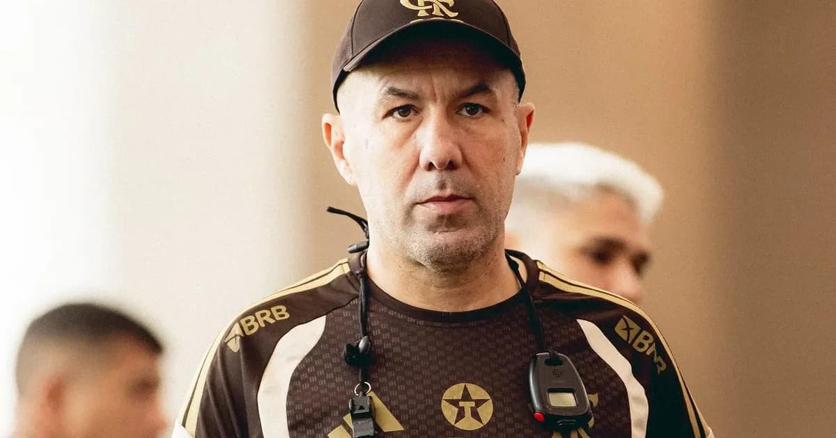Zagueiro argentino em ação no estádio à noite, scouts observando; imagem sobre monitoramento do Flamengo como possível reforço.