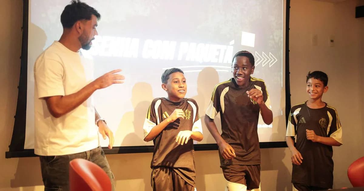 Encontro do Papo de Campeão: ex-jogador inspira jovens da base do Flamengo no campo, atmosfera inspiradora, cores vermelho e preto
