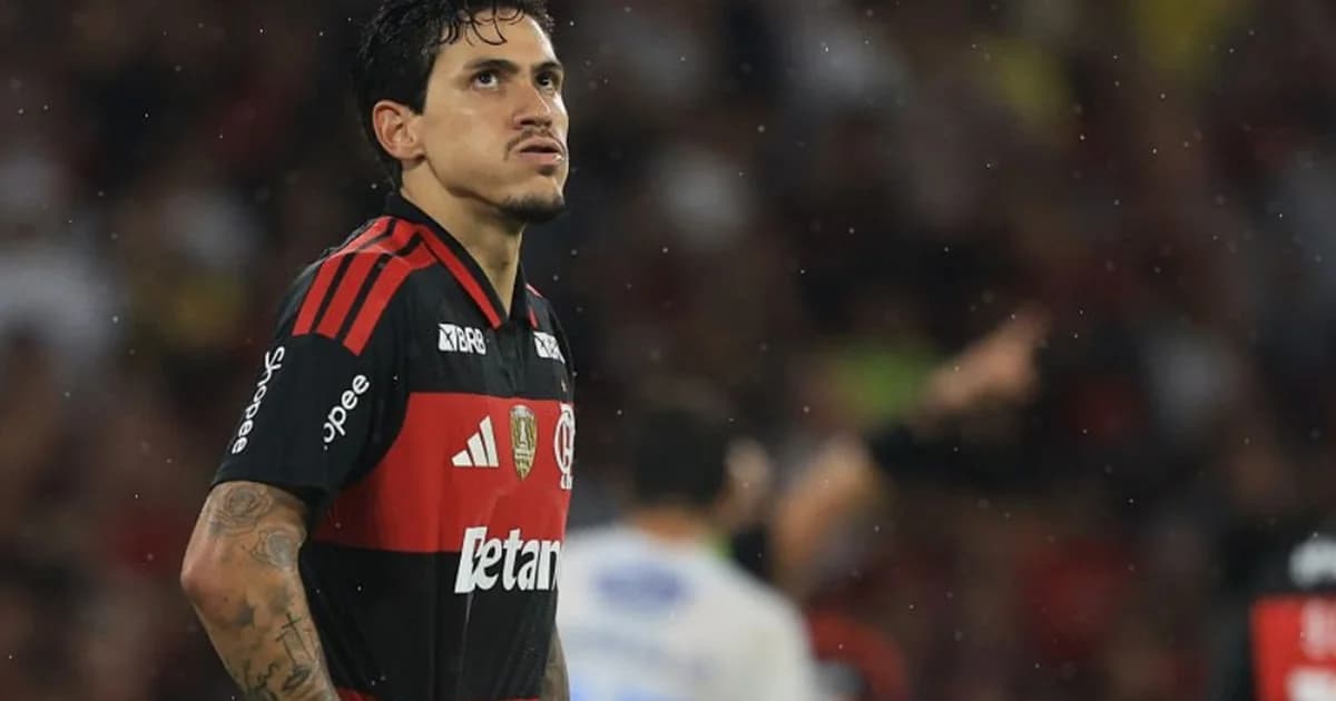 Atacante do Flamengo em ação, correndo e pressionando no estádio lotado ao entardecer, torcida vibrando