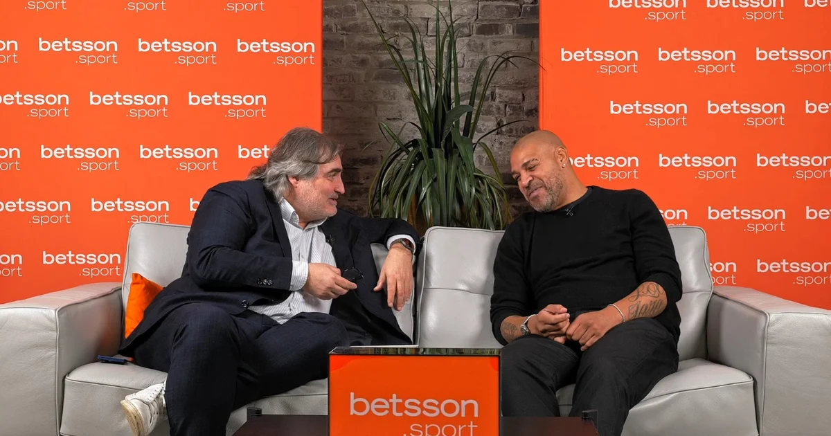 Silhueta de atacante inspirada em Adriano Imperador celebrando em estádio, atmosfera de 2004 e troféu dourado abstrato ao fundo.