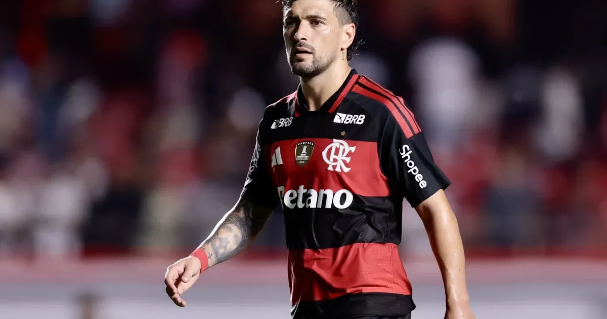 Ilustração editorial de jogador anônimo em uniforme vermelho e preto no estádio, simbolizando a esperança de Arrascaeta e do Flamengo na Recopa Sul-Americana.