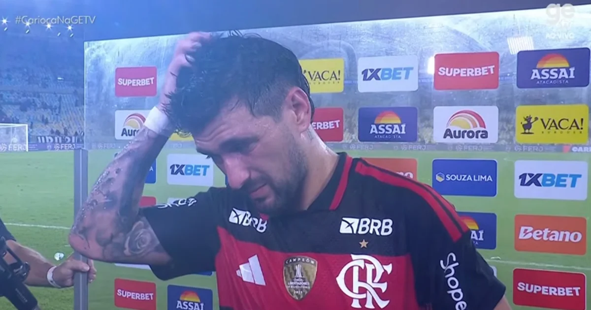 Meio-campista camisa 10 comemora gol 100 em estádio lotado, placar 3-0, torcida e atmosfera de determinação e recado ao elenco.