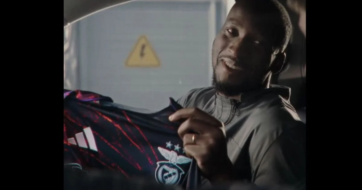 Ilustração editorial de estádio com painel publicitário rasgado e multidão protestando contra estereótipo racial.