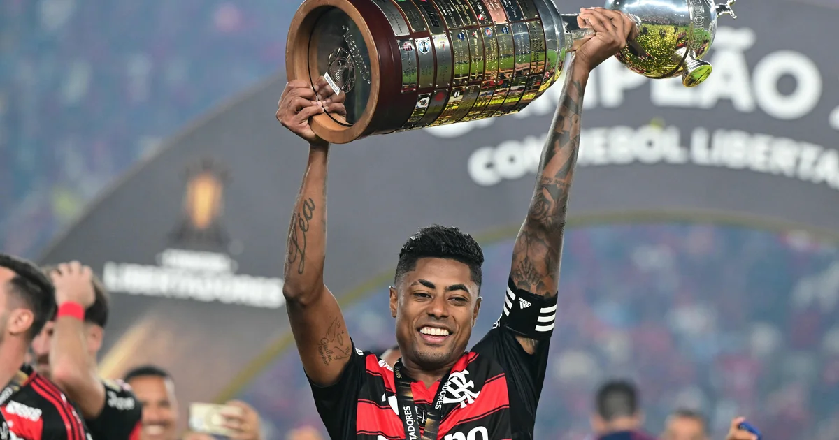 Atacante do Flamengo observa contrato em estádio ao entardecer; reunião, renovação e clima tenso sugeridos