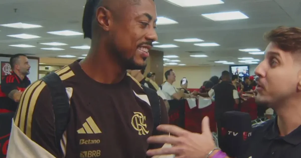 Atacante de costas com camisa 27 ergue microfone no gramado do Maracanã, torcida vibrando; retorno em busca da vitória.