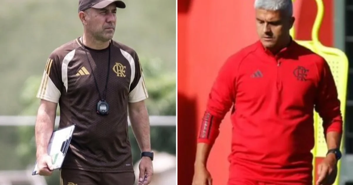 Técnico orienta preparador físico em treino no estádio ao amanhecer, comissão técnica e atletas em movimento.