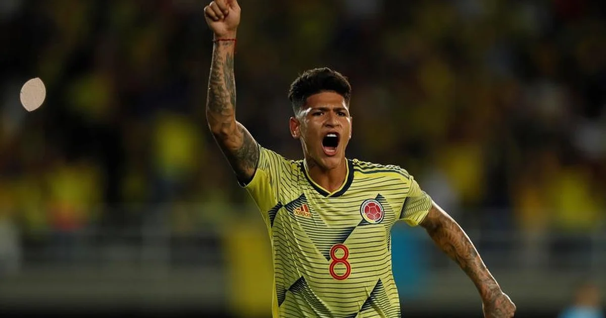 Ilustração de meio-campista colombiano efetuando passe decisivo no Estádio El Campín, torcida vibrando, placar 3 a 1