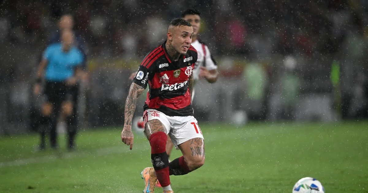 Atacante solitário de camisa rubro-negra genérica em estádio ao entardecer, contrato na bancada, clima de despedida — Cebolinha, Flamengo