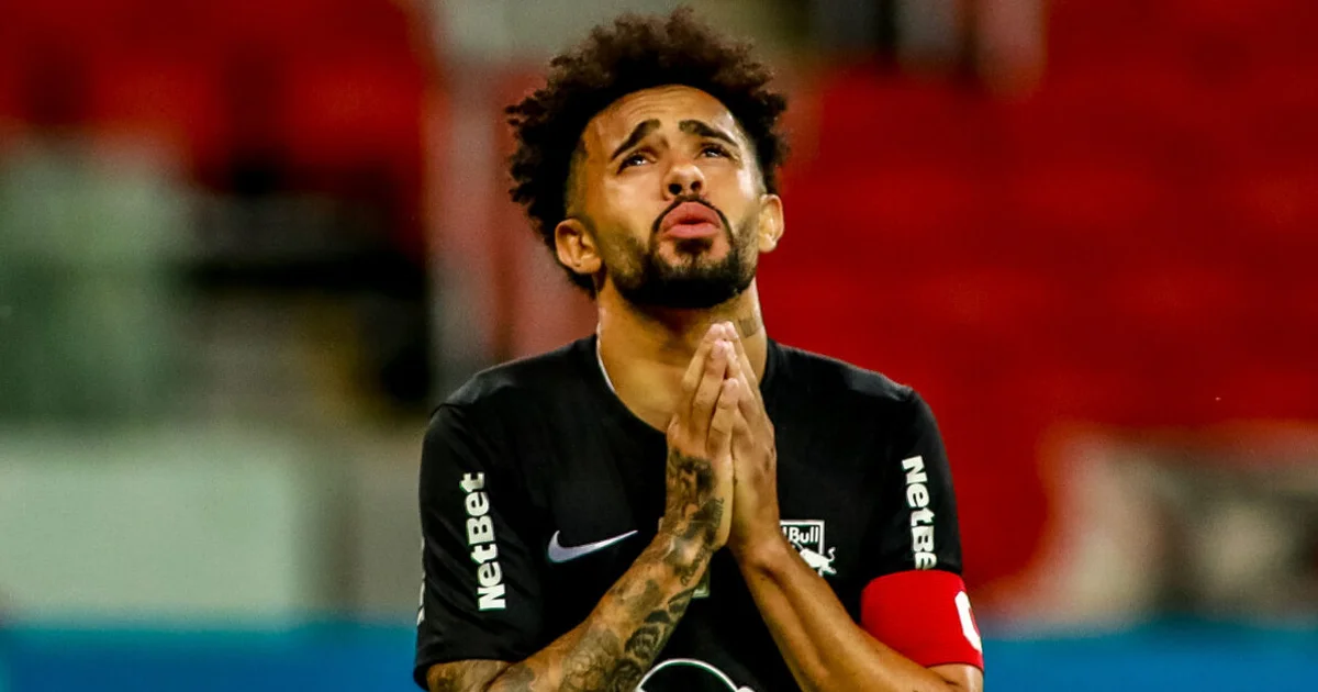 Silhueta de meia saindo de estádio à noite rumo ao aeroporto com a família; placar exibe comunicado urgente, clima tenso e incerto.