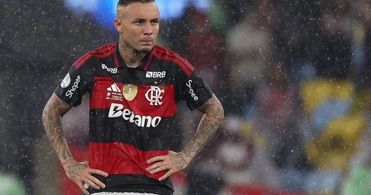 Atacante de costas em estádio vermelho e preto, caminhando ao túnel com mala; despedida e última temporada no futebol brasileiro.