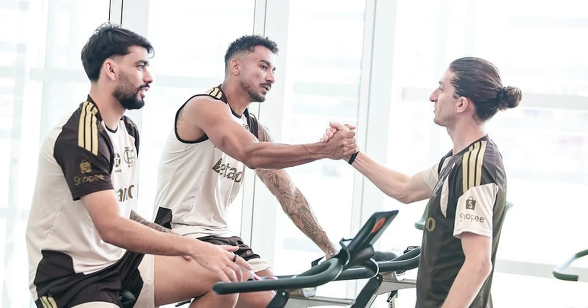 Filipe Luís em coletiva no Maracanã: treinador diante de microfones, silhueta de jogador em campo e símbolos contra o racismo