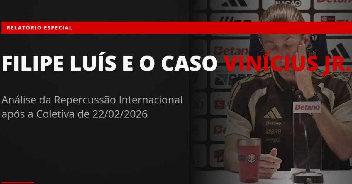Treinador apoia jogador negro no estádio contra o racismo, com torcida e imprensa ao fundo.