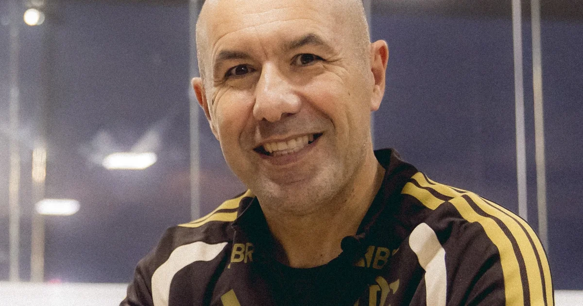 Novo técnico do Flamengo segura chaves em frente ao CT, dirigentes ao fundo, simbolizando gestão, entrega e renovação.