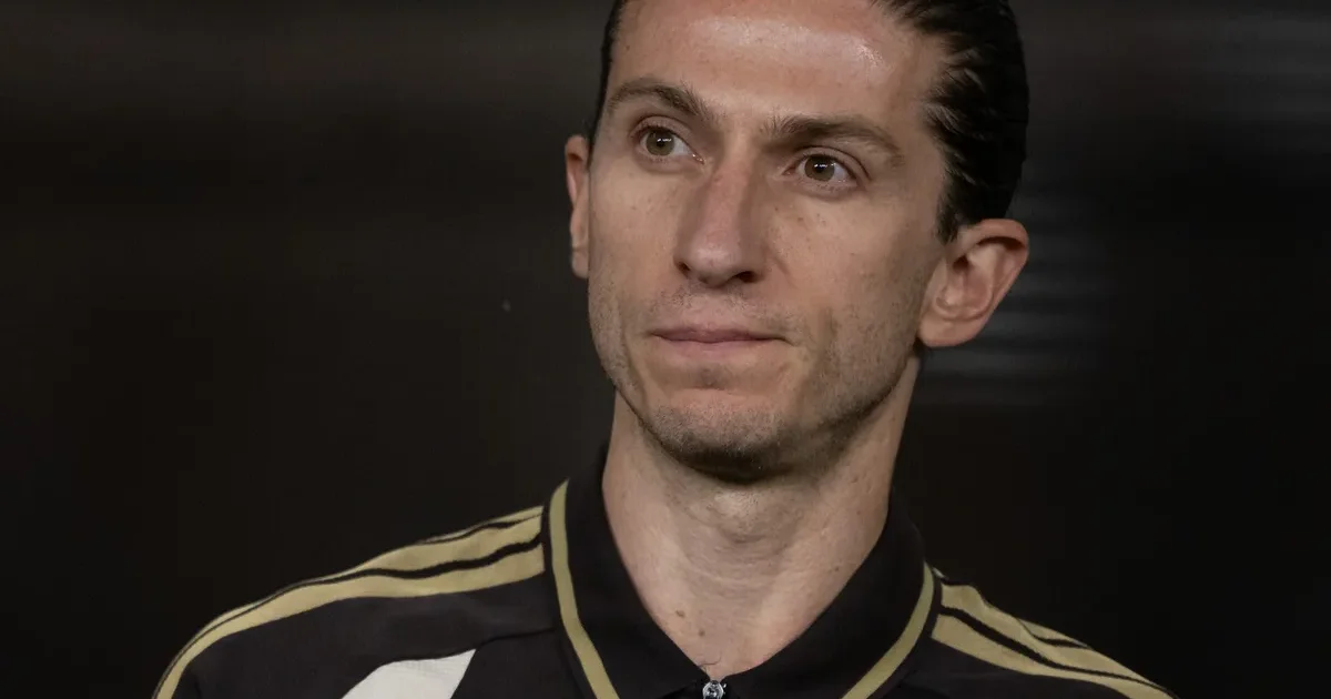 Ilustração editorial: centroavante móvel pressionando defesa, estádio lotado com cores vermelho e preto.