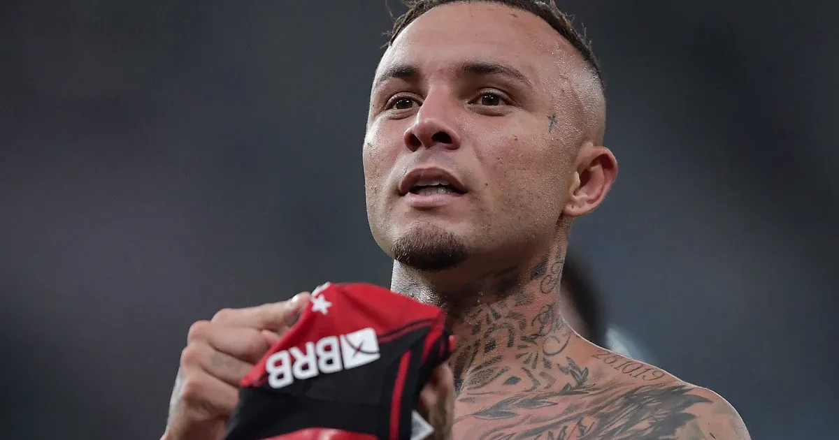 Comissão técnica do Flamengo reavalia elenco na pausa da Copa; atacante treina em estádio com tons vermelho e preto.