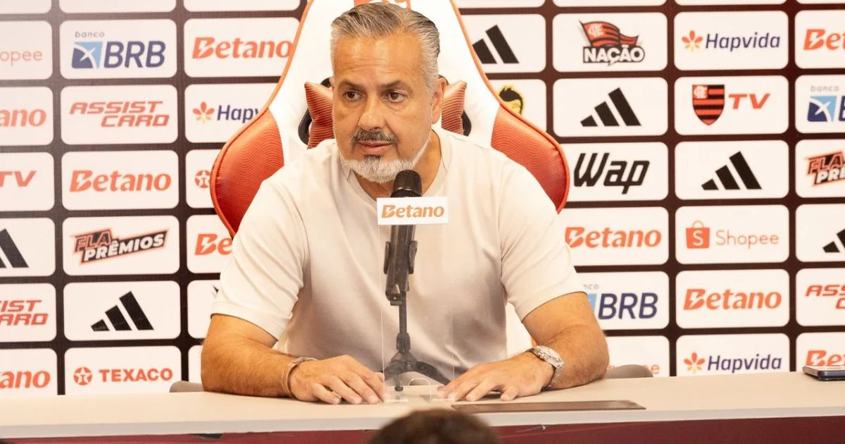 Dirigente sem rosto na beira do campo, estádio vazio em tons vermelho e preto, simbolizando crise interna do Flamengo