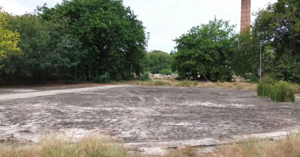 Estádio do Gasômetro do Flamengo parado, arquibancadas vazias, guindastes inativos e duas silhuetas em reunião, clima jurídico-político.