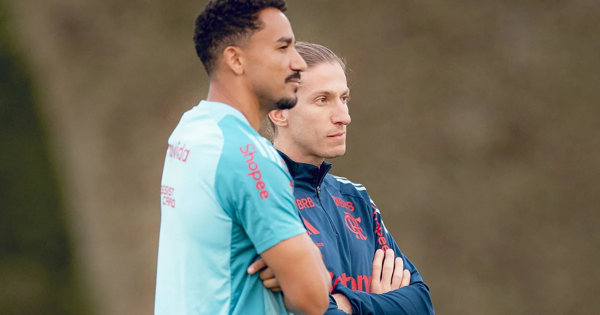 Técnico conversa com zagueiro e jovem atacante no Maracanã, gesto de apoio contra o racismo, torcida ao fundo