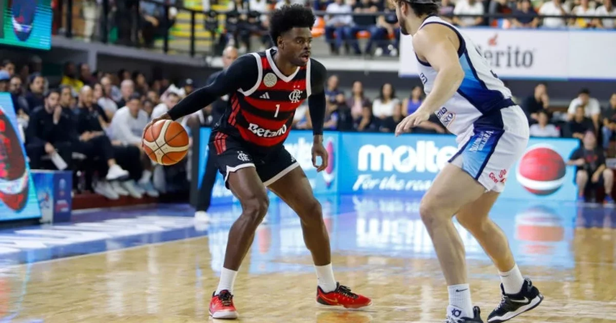 Jogador em vermelho e preto faz cesta no estouro do cronômetro; torcida vibra, placar 77–75 — BCLA Final Four