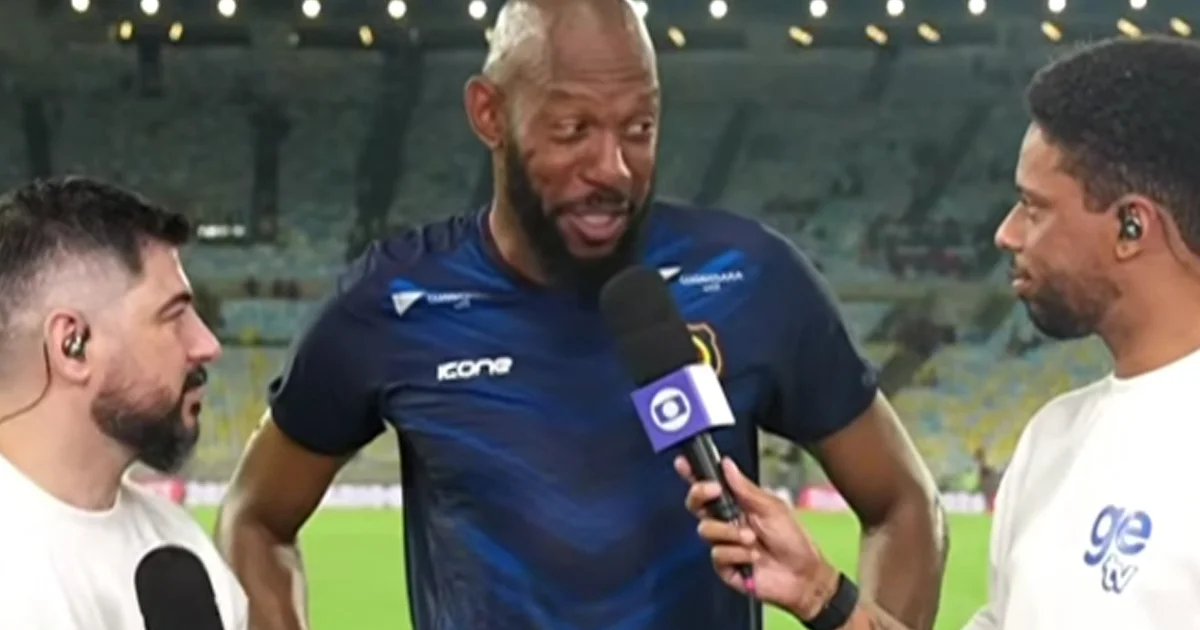 Goleiro do Madureira faz defesa espetacular em estádio lotado contra o Flamengo, com expressão cansada e determinada.