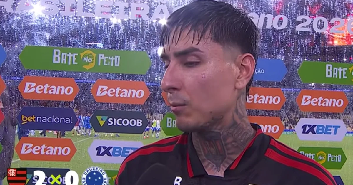 Treinador do Flamengo ajusta tática no banco enquanto jogadores comemoram vitória por 2 a 0 em estádio iluminado