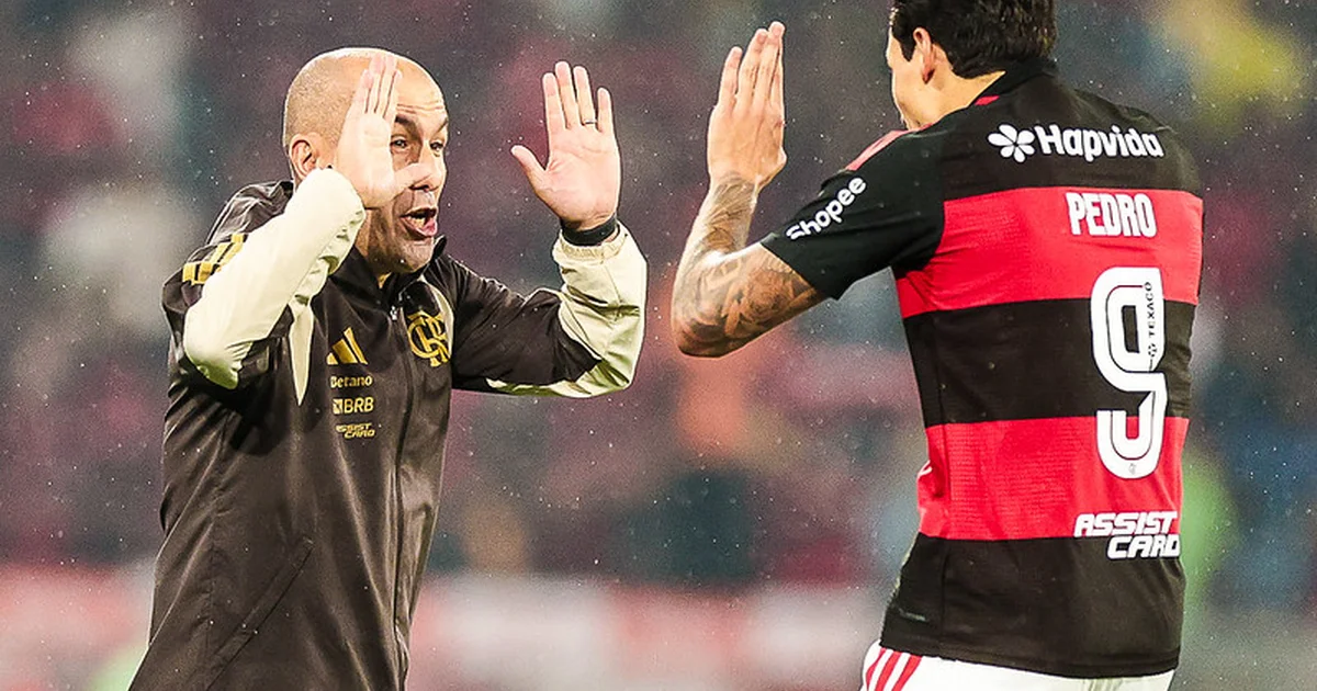 Treinador no Maracanã com quadro tático, jogadores anônimos em ação e atmosfera de vitória do Flamengo 2 a 0, foco tático e torcida